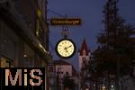 11.11.2022, Mindelheim (Unterallgäu) Stadtansicht, Abenddämmerung in der historischen Altstadt, die Hänge-Uhr an der Fassade eines Uhrengeschäfts zeigt die Zeit an.