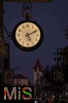 11.11.2022, Mindelheim (Unterallgäu) Stadtansicht, Abenddämmerung in der historischen Altstadt, die Hänge-Uhr an der Fassade eines Uhrengeschäfts zeigt die Zeit an.