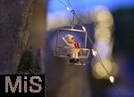 25.11.2022, Weihnachtsauslage in einer Gärtnerei in Buchloe (Bayern), Advent-Stimmung im Verkaufsraum. Funkelnde Lichter verschwimmen im Unscharfen. Vorne ein Deko-Anhänger mit einem Schneemann als Weihnachtsmann in einer Ski-Lift-Gondel.