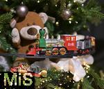 25.11.2022, Weihnachtsauslage in einer Gärtnerei in Buchloe (Bayern), Advent-Stimmung im Verkaufsraum. An einem Teddybär fährt eine Modelleisenbahn vorbei.