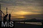 02.09.2023, Irland Land und Leute, Bantry im Sdwesten Irlands, County Cork. Neben dem Tourismus ist die Fischerei das zweite Standbein der Einwohner. Fischer steht am Pier im Abendrot beim Angeln.