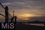 02.09.2023, Irland Land und Leute, Bantry im Südwesten Irlands, County Cork. Neben dem Tourismus ist die Fischerei das zweite Standbein der Einwohner. Fischer steht am Pier im Abendrot beim Angeln. 