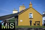 02.09.2023, Irland Land und Leute, Roadtrip am Ring of Kerry, der Kstenstrasse am Atlantik entlang im County Kerry.   Waterville Beach, Charlie Chaplin Cartoon an einer gelben Hausfassade.