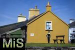 02.09.2023, Irland Land und Leute, Roadtrip am Ring of Kerry, der Kstenstrasse am Atlantik entlang im County Kerry.   Waterville Beach, Charlie Chaplin Cartoon an einer gelben Hausfassade.