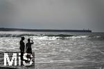 05.09.2023, Irland Land und Leute, Surfer- und Kstenstadt Tramore bei Waterford (Irland) im Sdosten. Mutter und Tochter stehen am Strand im Wasser und schauen aufs Meer hinaus.