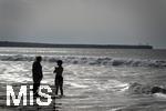 05.09.2023, Irland Land und Leute, Surfer- und Kstenstadt Tramore bei Waterford (Irland) im Sdosten. Mutter und Tochter stehen am Strand im Wasser und schauen aufs Meer hinaus.