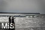 05.09.2023, Irland Land und Leute, Surfer- und Kstenstadt Tramore bei Waterford (Irland) im Sdosten. Mutter und Tochter stehen am Strand im Wasser und schauen aufs Meer hinaus.