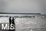 05.09.2023, Irland Land und Leute, Surfer- und Kstenstadt Tramore bei Waterford (Irland) im Sdosten. Mutter und Tochter stehen am Strand im Wasser und schauen aufs Meer hinaus.