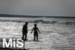 05.09.2023, Irland Land und Leute, Surfer- und Kstenstadt Tramore bei Waterford (Irland) im Sdosten. Mutter und Tochter stehen am Strand im Wasser und schauen aufs Meer hinaus.