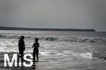 05.09.2023, Irland Land und Leute, Surfer- und Kstenstadt Tramore bei Waterford (Irland) im Sdosten. Mutter und Tochter stehen am Strand im Wasser und schauen aufs Meer hinaus.