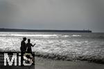 05.09.2023, Irland Land und Leute, Surfer- und Kstenstadt Tramore bei Waterford (Irland) im Sdosten. Mutter und Tochter stehen am Strand im Wasser und schauen aufs Meer hinaus.