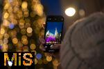 20.11.2023, Hauptstadt Wien (sterreich) erstrahlt im vorweihnachtlichem Glanz, Impressionen vom Weihnachtsmarkt am bunt beleuchteten Stephansdom. Eine Touristin fotografiert mit ihrem Handy.
