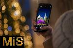 20.11.2023, Hauptstadt Wien (sterreich) erstrahlt im vorweihnachtlichem Glanz, Impressionen vom Weihnachtsmarkt am bunt beleuchteten Stephansdom. Eine Touristin fotografiert mit ihrem Handy.
