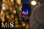 20.11.2023, Hauptstadt Wien (Österreich) erstrahlt im vorweihnachtlichem Glanz, Impressionen vom Weihnachtsmarkt am bunt beleuchteten Stephansdom. Eine Touristin fotografiert mit ihrem Handy.