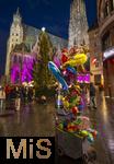 20.11.2023, Hauptstadt Wien (Österreich) erstrahlt im vorweihnachtlichem Glanz, Impressionen vom Weihnachtsmarkt am bunt beleuchteten Stephansdom. Ein Händler im Clownkostüm verkauft bunte Tier-Luftballons.