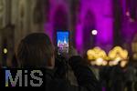 20.11.2023, Hauptstadt Wien (Österreich) erstrahlt im vorweihnachtlichem Glanz, Impressionen vom Weihnachtsmarkt am bunt beleuchteten Stephansdom. Ein Tourist fotografiert mit seinem Handy.