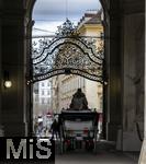 21.11.2023, sterreich, die Hauptstadt Wien. Ein Fiaker fhrt Touristen durch die malerische Altstadt durch ein Tor. 