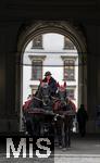 21.11.2023, Österreich, die Hauptstadt Wien. Ein Fiaker fährt Touristen durch die malerische Altstadt durch ein Tor.   