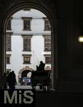 21.11.2023, Österreich, die Hauptstadt Wien. Ein Fiaker fährt Touristen durch die malerische Altstadt durch ein Tor. 