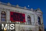 21.11.2023, sterreich, die Hauptstadt Wien. Impressionen vom festlich beleuchteten Burgtheater im Abendlicht. Mit einem Plakat AUFWACHEN BEVOR ES WIEDER FINSTER WIRD, hinten geht der Mond auf.