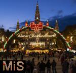 21.11.2023, sterreich, die Hauptstadt Wien. Impressionen vom Weihnachtsmarkt vor dem festlich beleuchteten Rathaus im Abendlicht. Hier das groe Eingangstor mit einem Karussell.