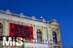 21.11.2023, sterreich, die Hauptstadt Wien. Impressionen vom festlich beleuchteten Burgtheater im Abendlicht. Mit einem Plakat AUFWACHEN BEVOR ES WIEDER FINSTER WIRD