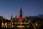 21.11.2023, sterreich, die Hauptstadt Wien. Impressionen vom Weihnachtsmarkt vor dem festlich beleuchteten Rathaus im Abendlicht. Hier das groe Eingangstor mit einem Karussell. 