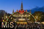 21.11.2023, sterreich, die Hauptstadt Wien. Impressionen vom Weihnachtsmarkt vor dem festlich beleuchteten Rathaus im Abendlicht. Hier das groe Eingangstor mit einem Karussell.