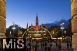 21.11.2023, sterreich, die Hauptstadt Wien. Impressionen vom Weihnachtsmarkt vor dem festlich beleuchteten Rathaus im Abendlicht. Hier das groe Eingangstor mit einem Karussell.