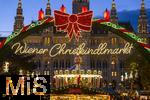 21.11.2023, sterreich, die Hauptstadt Wien. Impressionen vom Weihnachtsmarkt vor dem festlich beleuchteten Rathaus im Abendlicht. Hier das groe Eingangstor mit einem Karussell.