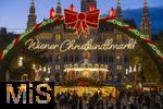 21.11.2023, sterreich, die Hauptstadt Wien. Impressionen vom Weihnachtsmarkt vor dem festlich beleuchteten Rathaus im Abendlicht. Hier das groe Eingangstor mit einem Karussell.