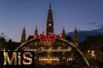 21.11.2023, sterreich, die Hauptstadt Wien. Impressionen vom Weihnachtsmarkt vor dem festlich beleuchteten Rathaus im Abendlicht. Hier das groe Eingangstor mit einem Karussell. 