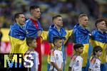 03.06.2024, Fussball Nationalteams Freundschaftsspiele 2024, Lnderspiel, Deutschland - Ukraine, im Max-Morlock-Stadion (Nrnberg). Ukrainische Spieler mit ihrer Nationalflagge um die Schuler bei ihrer Nationalhymne 