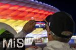 14.06.2024, Fussball UEFA EURO 2024, Vorrunde, 1.Spieltag, Erffnungsspiel Deutschland - Schottland, in der Fuball Arena Mnchen. Das Stadion ist aussen mit den Landesflaggen (Deutschland und Schottland) illuminiert.  Ein Fan fotografiert es mit seinem Handy.