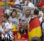 05.07.2024, Fussball UEFA EURO 2024, Viertelfinale, Spanien - Deutschland, in der Stuttgart-Arena. Zwei Deutsche Fans mit berdimensionalen Quartett-Spielkarten der EM 1988, von Lothar Matthus und Rudi Vller, in die sie ihre Kpfe gesteckt haben.

