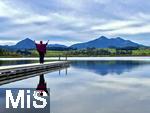 13.10.2024, Hopfensee in Bayern, Der Hopfensee bei Fssen im Allgu,  auf dem Steg direkt am See nutzen Urlauber die ruhige Landschaft zur Meditation und Entspannungsbungen.