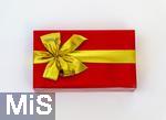 20.01.2025,  Weihnachtsgeschenk, Geburtstagsgeschenk, Rote Papierverpackung mit goldener Schleife umwickelt.