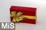 20.01.2025,  Weihnachtsgeschenk, Geburtstagsgeschenk, Rote Papierverpackung mit goldener Schleife umwickelt.