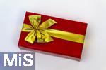 20.01.2025,  Weihnachtsgeschenk, Geburtstagsgeschenk, Rote Papierverpackung mit goldener Schleife umwickelt.