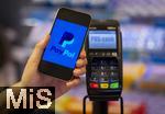 05.05.2025, Symbolbild kontaktloses Bezahlen mit dem iPhone und PaypAl bald auch mglich in Deutschland, eine Frau bezahlt mit Smartphone mittels PayPal-App in einem Laden an der Kasse. 