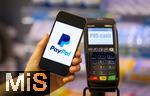 05.05.2025, Symbolbild kontaktloses Bezahlen mit dem iPhone und PaypAl bald auch mglich in Deutschland, eine Frau bezahlt mit Smartphone mittels PayPal-App in einem Laden an der Kasse. 