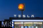 04.05.2025, Bayreuth, (Bayern), Die US-Firma Tesla hat hier einen Ladepark fr E-Autos an der Autobahn A9. An 20 modernen Schnell-Ladesulen knnen hier Teslafahrer und andere E-Auto-Fabrikate ihren Auto-Akku aufladen. Alle Stalls sind Supercharger Version V4. Die Wartezeit knnen sich die Autofahrer in einer Lounge der Firma bk-World vertreiben, mit Toiletten, Ruherume, Getrnke und Snack-Automaten und Sitzmglichkeiten etc.     Hinten ist eine Shell-Tankstelle.