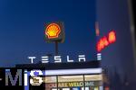 04.05.2025, Bayreuth, (Bayern), Die US-Firma Tesla hat hier einen Ladepark fr E-Autos an der Autobahn A9. An 20 modernen Schnell-Ladesulen knnen hier Teslafahrer und andere E-Auto-Fabrikate ihren Auto-Akku aufladen. Alle Stalls sind Supercharger Version V4. Die Wartezeit knnen sich die Autofahrer in einer Lounge der Firma bk-World vertreiben, mit Toiletten, Ruherume, Getrnke und Snack-Automaten und Sitzmglichkeiten etc.     Hinten ist eine Shell-Tankstelle.
