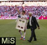 10.05.2025, Fussball 1. Bundesliga 2024/2025, 33. Spieltag,  FC Bayern Mnchen - Borussia Mnchengladbach, in der Allianz-Arena Mnchen. Thomas Mller (FC Bayern Mnchen) trgt sein Gastgeschenk zu seiner Verabschiedung der Gladbacher weg.  re: Rainer Bonhof (Prsident Mnchengladbach)