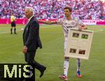 10.05.2025, Fussball 1. Bundesliga 2024/2025, 33. Spieltag,  FC Bayern Mnchen - Borussia Mnchengladbach, in der Allianz-Arena Mnchen. Thomas Mller (FC Bayern Mnchen) trgt sein Gastgeschenk zu seiner Verabschiedung der Gladbacher weg.  li: Rainer Bonhof (Prsident Mnchengladbach)