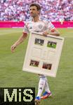 10.05.2025, Fussball 1. Bundesliga 2024/2025, 33. Spieltag,  FC Bayern Mnchen - Borussia Mnchengladbach, in der Allianz-Arena Mnchen. Thomas Mller (FC Bayern Mnchen) trgt sein Gastgeschenk zu seiner Verabschiedung der Gladbacher weg. 
