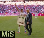10.05.2025, Fussball 1. Bundesliga 2024/2025, 33. Spieltag,  FC Bayern Mnchen - Borussia Mnchengladbach, in der Allianz-Arena Mnchen. Thomas Mller (FC Bayern Mnchen) trgt sein Gastgeschenk zu seiner Verabschiedung der Gladbacher weg.  re: Rainer Bonhof (Prsident Mnchengladbach)
