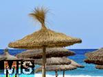 03.06.2025,  Beliebtes Reiseziel der Deutschen, Mallorca.  Cala Ratjada am Strand Cala Agulla. Landestypische Stroh-Sonnenschirme am Strand.