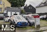 04.06.2025, Mnchen (Bayern), nachdem am Abend in der Region ein gefhrliches Gewitter mit Hagelschlag angekndigt wurde, hat dieser Autohndler in Mnchen vorsorglich seine Autos auf Halde mittels Teppichen, Leitern und Autoreifen vor Beschdigungen geschtzt.
