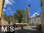29.6.2025, Meran in S�dtirol, Italien. Innenstadt Meran, Kirchturm der Stadtpfarrkirche St. Nikolaus Meran,  Marktst�nde am Pfarrplatz.
